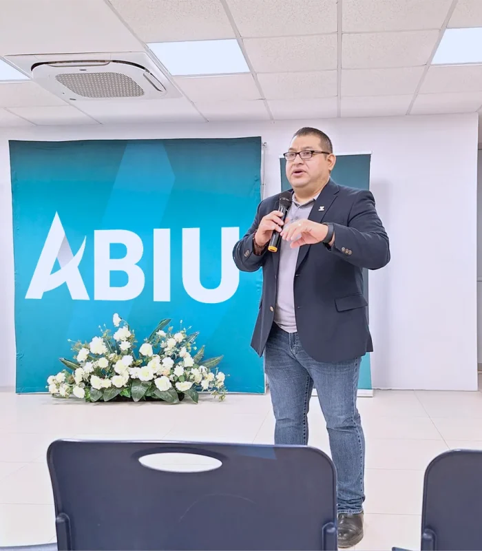 Dr. Abiu Ixba impartiendo una conferencia en un evento profesional sobre liderazgo transformador y desarrollo personal.